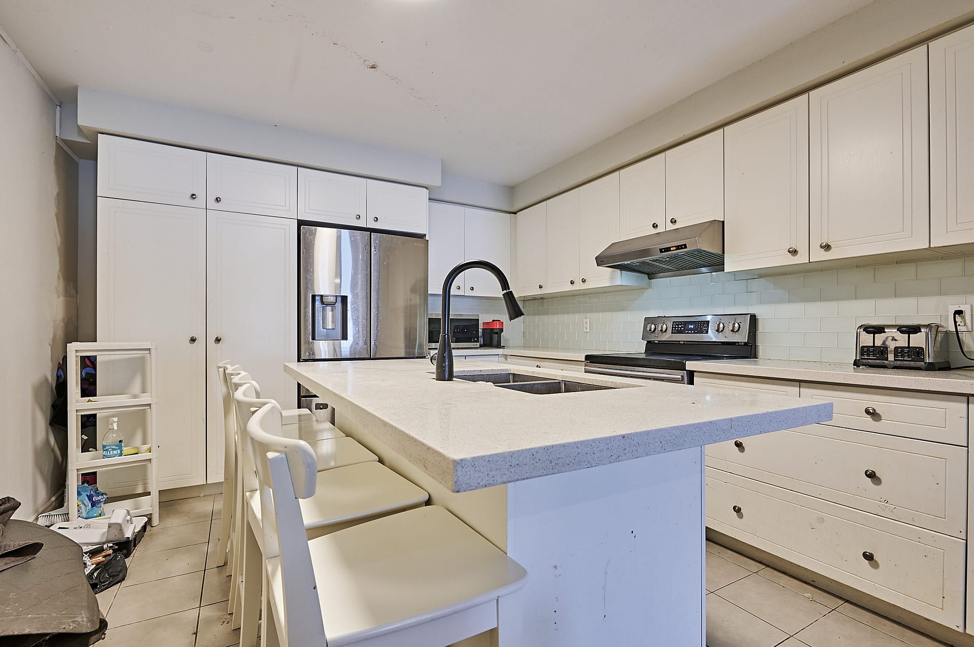Before: Cluttered kitchen with lived-in items visible in real estate listing photo